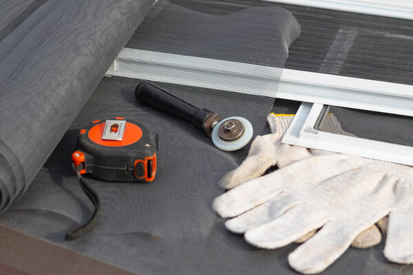 Образцы противомоскитных сеток. На открытом воздухе. Настольный компьютер, на котором будут собираться продукты на окне. На заднем плане деревянный фон в стиле ретро бордового цвета
.