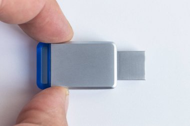 USB Flaş Beyaz arka plan. Üzerinde metal bir parıltı var. Yakın plan. Şapka kayıp..