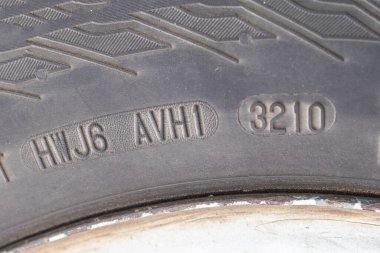 stamping on a tire where date and year of issue are indicated. Close-up. Old wheel, replacement required. clipart