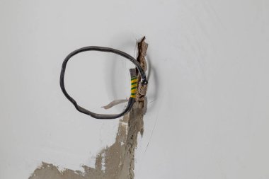 Alçılı beyaz duvar. Prizleri bağlamak için bir kablo görüntüler. Uzayı kopyala Yakın plan.