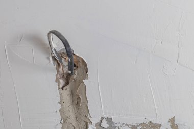 Alçılı beyaz duvar. Prizleri bağlamak için bir kablo görüntüler. Uzayı kopyala Yakın plan.