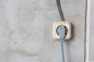 Elektrik prizleri lamba montajı ve sıva duvar arka planında kurulumu yapıyor. Elektrik prizlerinin, kabloların ve anahtarların profesyonel kurulumu. Yan görünümü kapat