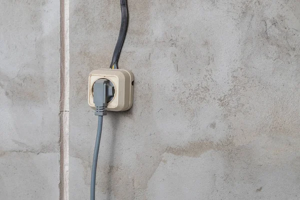 Electric sockets light works mounting and installation on plaster wall background. Professional installation of electrical outlets, wires and switches. Close up side view