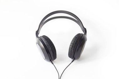 Beyaz arka plan. İçinde müzik dinlemek için kulaklıklar var, siyah. Yakın plan..