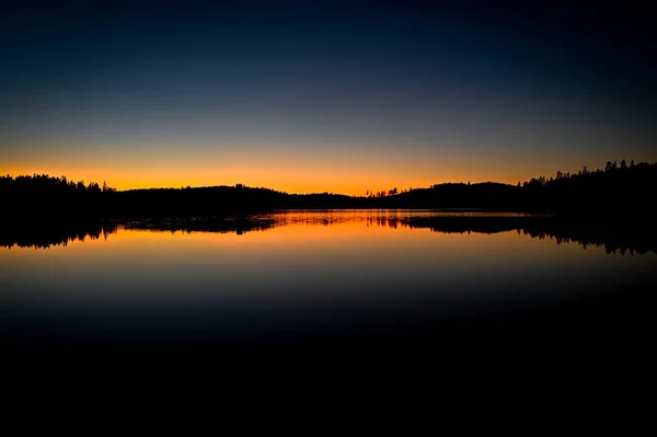 Puesta de sol panorámica sobre un lago tranquilo en Varmland Suecia — Foto de Stock