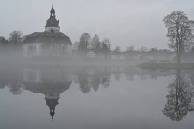 İsveç 'teki Filipstad gölünün ve kilisenin üzerindeki sis.