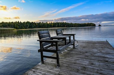 pair of chairs on a wooden jetty in lake Vattern Sweden