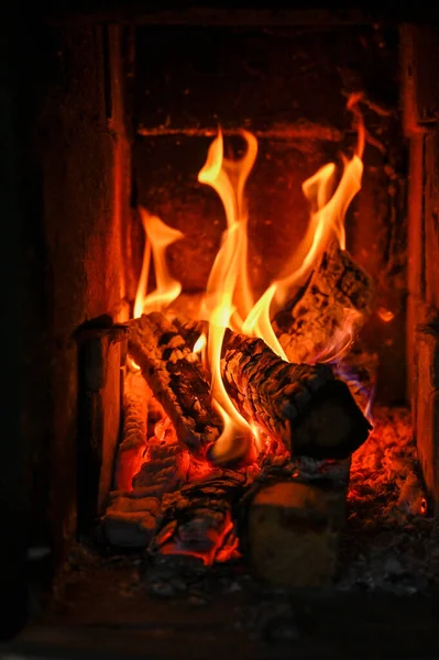 Fuego en una estufa de azulejos en una cabina — Foto de Stock