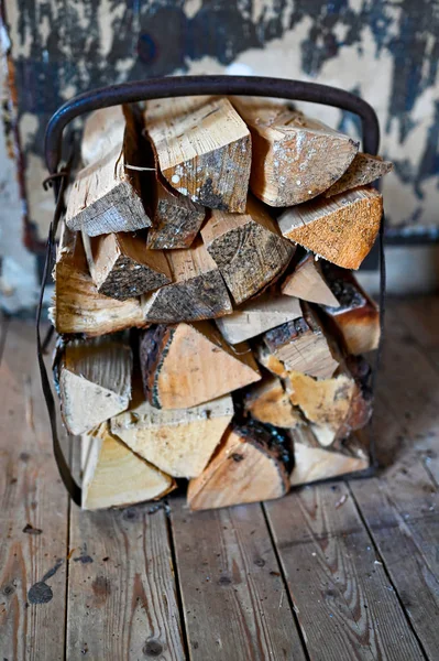 Panier de bois de chauffage debout sur le sol en bois à l'intérieur — Photo