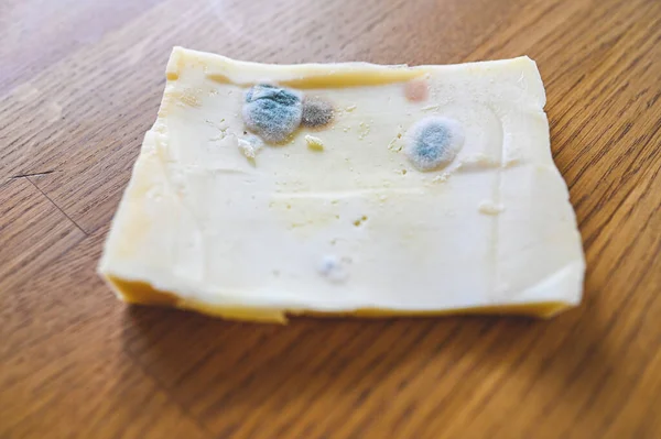 Queso con fecha de caducidad pasada en la mesa de la cocina — Foto de Stock