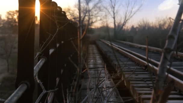 Alte rostige Brücke und verlassene Eisenbahngleise bei Sonnenuntergang. Vergrößern. — Stockvideo