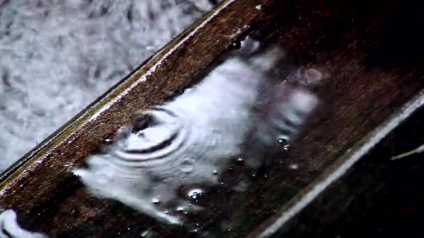 Gotas de lluvia gotean en la cubierta de madera durante la tormenta pesada. Primer plano. — Vídeo de stock