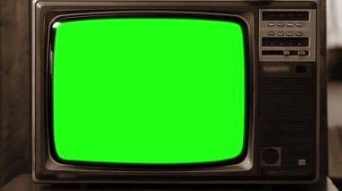 Bir odada yeşil ekranlı eski bir televizyon. Hızlıca yakınlaştır. Sepia Tone. Yeşil ekranı istediğin görüntüyle ya da resimle değiştirebilirsin. Sonraki Efektler ya da herhangi bir video düzenleme yazılımında Keying efekti ile yapabilirsiniz (Youtube 'daki derslere bakın). 