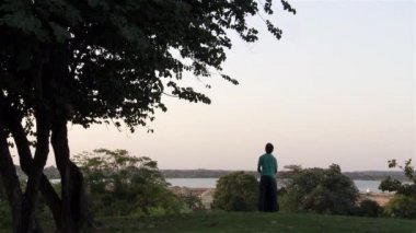 Asuncin 'de Günbatımını izleyen genç gitarist (Paraguay). 