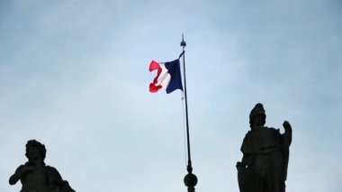Paris 'te eski bir binanın üzerinde dalgalanan Fransa bayrağı. 
