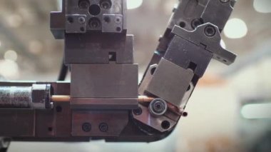 Buzdolabı fabrikasındaki bakır tüpleri kesen robotik kol. Uzaklaş. Yakın plan. 
