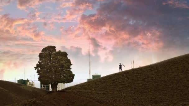 最後のフロンティアだ 緑の丘の上に立つ男と背景に立ち上がる混雑した都市 生態学的希望概念 — ストック動画