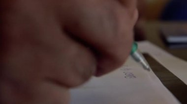 Yeşil Kalem Kullanarak Kağıda Yazan Kişi. Yakın plan.