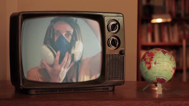 回転世界地図の近くのレトロなテレビで呼吸マスクを持つ女性 コロナウイルスパンデミックアウトブレイクコンセプトビデオ — ストック動画