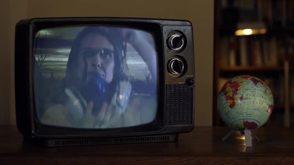 在复古电视上戴着呼吸面具的女人 屏幕上的反乌托邦世界 黑暗之轮 — 图库视频影像