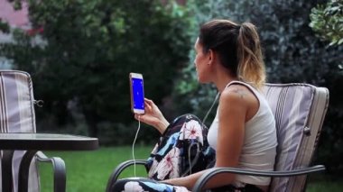 COVID-19 salgını sırasında mavi ekranlı akıllı telefon kullanan bir kadın. Mavi ekranı istediğiniz görüntüyle ya da resimle değiştirebilirsiniz. Sonraki Efektler ya da diğer herhangi bir video düzenleme yazılımında Keying efekti ile yapabilirsiniz.