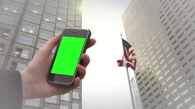 Miami Financial Miami Center ve ABD Bayrağı altında eski bir Smarphone Green Screen tutuyor. Yeşil ekran ile istediğiniz görüntüyü ya da resmi Keying efektiyle değiştirebilirsiniz.