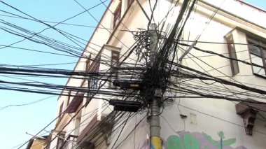Bolivya, La Paz 'daki bir koloni binasının elektrik direğinde dağınık kablolar ve kablolar.. 