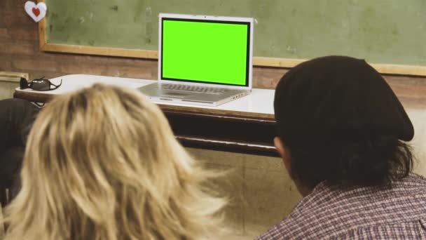 学校に座って 緑の画面でノートパソコンを見ている人 緑の画面を必要な映像や画像に置き換えることができます Effectsやその他のビデオ編集ソフトウェアのキーエフェクトで実行できます — ストック動画