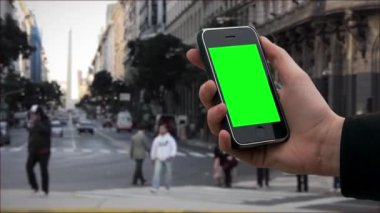 Buenos Aires 'te yeşil ekranlı eski akıllı bir telefon tutan erkek eller. Yeşil ekranı istediğin görüntüyle ya da resimle değiştirebilirsin. Sonraki Efektler 'de tuşlama efekti ile yapabilirsiniz.