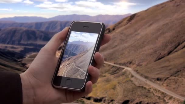 アルゼンチンのアルティプラノ州7月のリパン斜面にある古いスマートフォンで写真を撮る男性の手 — ストック動画