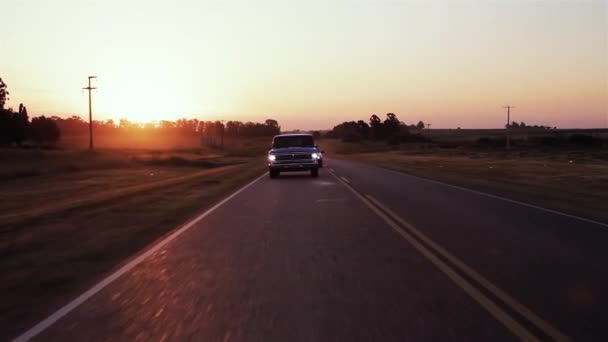 日没時に道路上の青いピックアップトラック — ストック動画