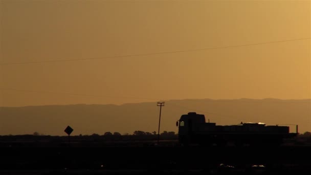 日落大道上一辆卡车的轮廓 侧视图 — 图库视频影像