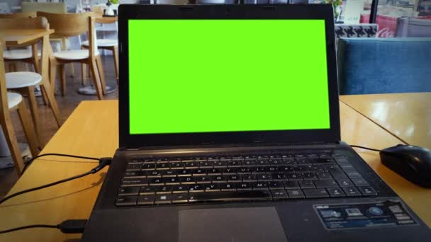 在自助餐厅的木桌上装有绿色屏风的笔记本电脑 — 图库视频影像