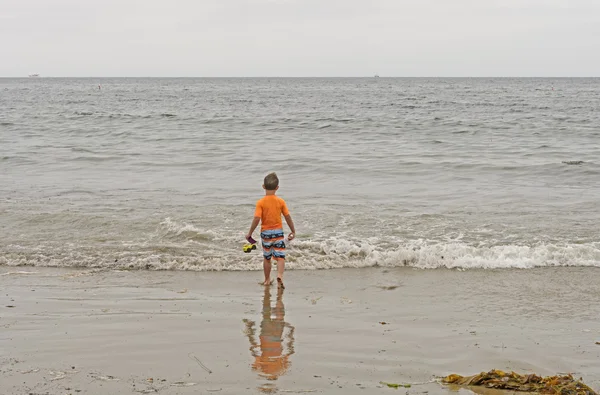 Мальчик, уходящий в океан — стоковое фото