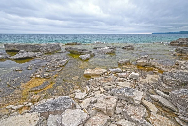 Skalnaté pobřeží vyhlíží k jezeru — Stock fotografie
