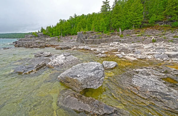 Rocas y pinos a orillas de un lago remoto — Foto de Stock