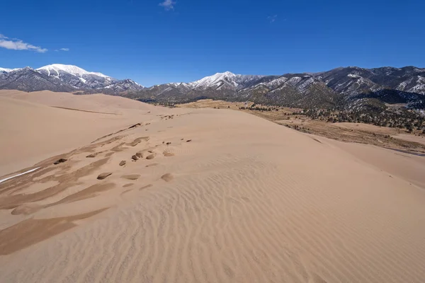 Dunas de arena en medio de las montañas nevadas — Foto de Stock