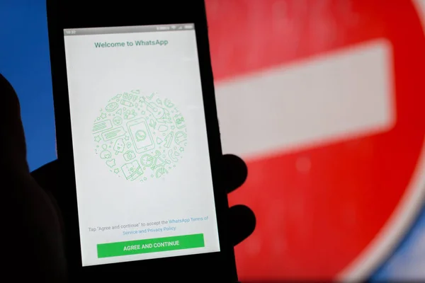 Moskova, Rusya - 16 Nisan 2018: cep telefonu ile Whatsapp uygulama yasaklayan bir işaret karşı elinde. Rusya, İstihbarat teşkilatları kullanıcı yazışma denetlemek şifre çözme anahtarları sağlamak için Instant messengers yaratıcıları gerektirir..