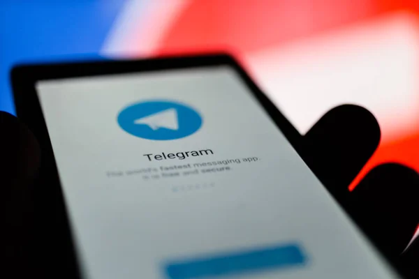 MOSCOW, RÚSSIA - 16 de abril de 2018: Um telefone celular com o aplicativo Telegram na mão contra um sinal de proibição. Na Rússia, o popular mensageiro do Telegrama é proibido. Por decisão do tribunal Tagansky Roskomnadzor bloqueou o serviço Telegram . — Fotografia de Stock