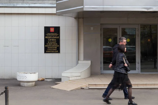 俄罗斯莫斯科--2 0 1 8年 4月 3 0日: 两人经过 Roskomnadzor 大楼入口。在萨哈罗夫大道集会后反对封锁在俄罗斯的电报信使. — 图库照片
