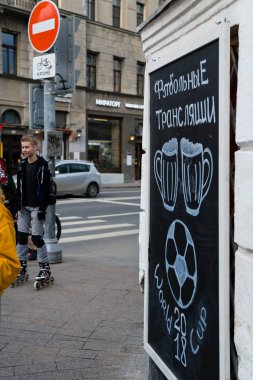 Moskova, Rusya - 30 Nisan 2018: Solyansky proezd Dünya Futbol Şampiyonası mundialia FIFA 2018 futbol yayınlarını reklam ile kara tahta yakın kişi. Bira spor bar.