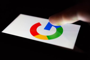 Moskova, Rusya - 9 Mayıs 2018: Google logo görüntüleme karanlıkta bir masada yalan bir smartphone. Parmak dokunmatik ekran üzerinde. Enterne dalga köpüğü bağımlılığını kavramı.