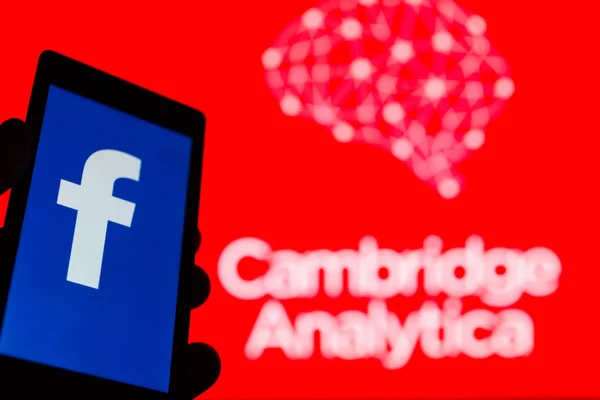 Moskova, Rusya - 9 Mayıs 2018: Smartphone popüler sosyal ağ Facebook logolu elinde. Cambridge Analytica amblem arka planda. Genel veri koruma Yönetmeliği (Gdpr) kavramı. Sansür