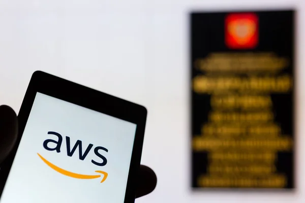 Moskou, Rusland -, 9 mei 2018: Smartphone in de hand met Amazon Web Services (Aws) logo. Roskomnadzor (Rkn) kantoor op achtergrond. Miljoenen van Ip is geblokkeerd voor een verbod op Telegram app messenger. Censuur. VPN — Stockfoto