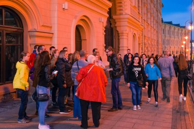 Moskova, Rusya - 30 Nisan 2018: Turist kırmızı kare üzerinde Aziz Basil Katedrali yakınındaki bir grup ile bir rehber. İyi akşamlar, gün batımından önce alacakaranlık 