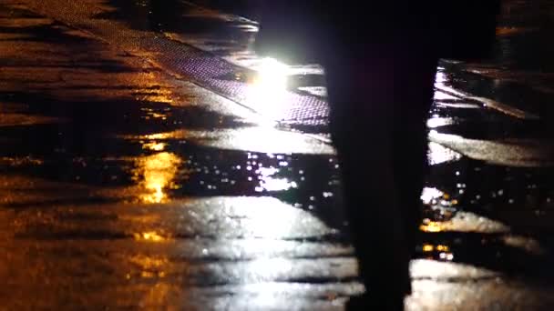 Silhueta de figura masculina em capa de chuva no fundo de asfalto molhado na rua — Vídeo de Stock