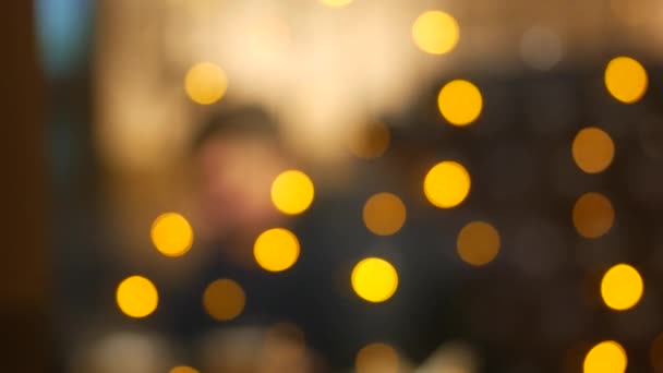 Feux de vacances jaunes. Silhouettes floues des visiteurs du café aux tables 