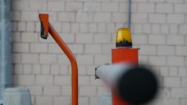Oranje slagboom wordt geïnstalleerd voordat u de binnenplaats van de rijbaan. Wind schudt — Stockvideo