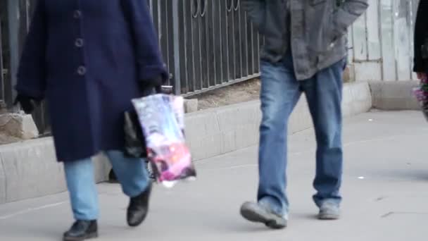 Бедный пожилой человек в зимнем пальто сидит на улице с одноразовой чашкой в руках — стоковое видео