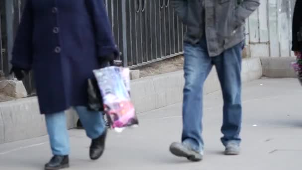 Pauper elderly man in winter coat sits on street with a disposable cup in hands — Stock Video